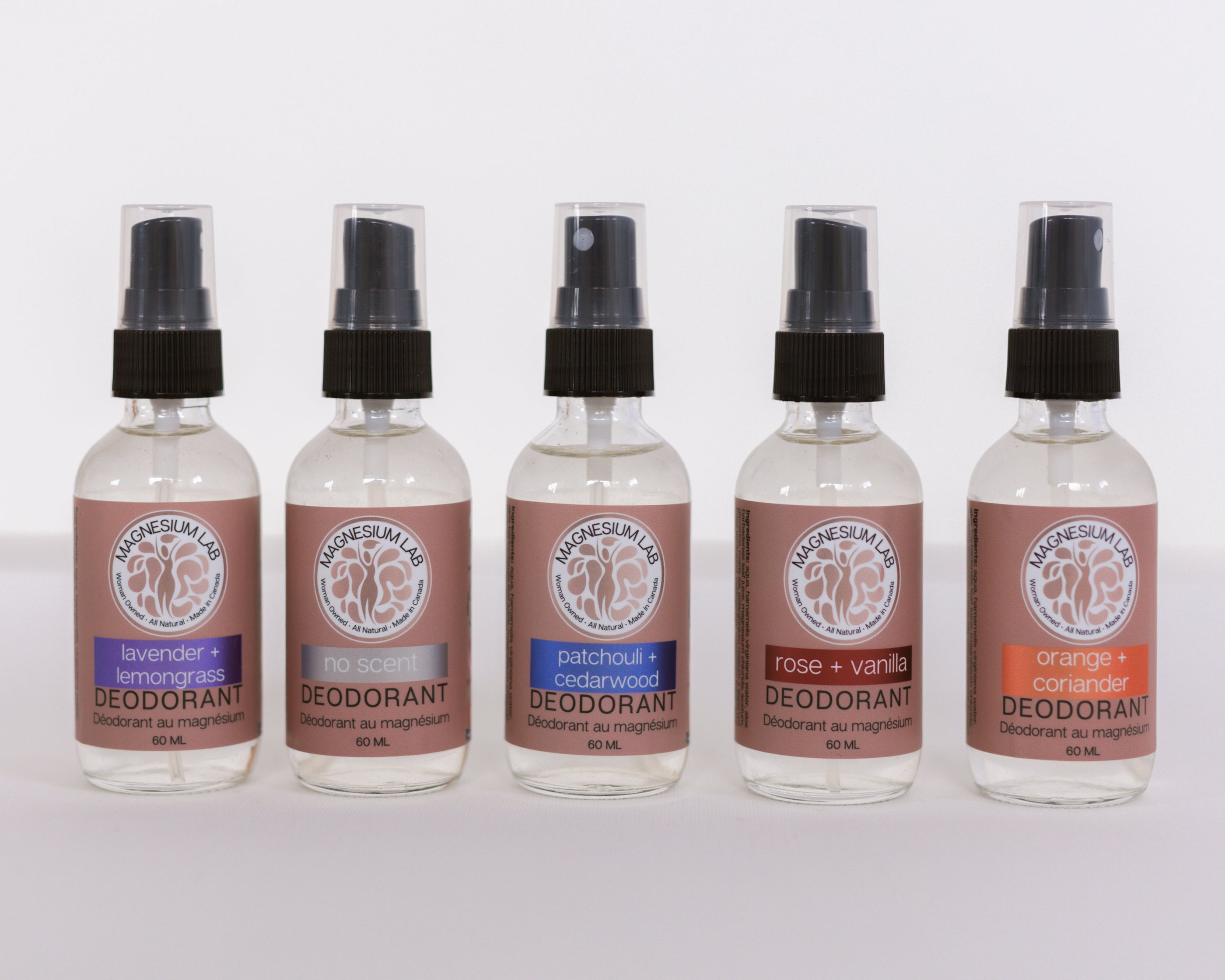 Image shows all 6 variants of magnesium deodorant spray layed out along a pink ribbon